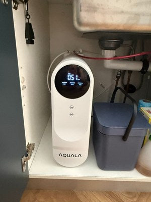 A customer's P500 standing on the shelf of a kitchen under-sink cupboard, with a small bin beside it.