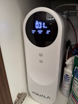 A customer's P500 standing in an under-sink cupboard, with a spray bottle beside it.