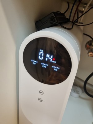 Close-up of a customer's P500 display and top, with the power adapter and cables above it in the cupboard.