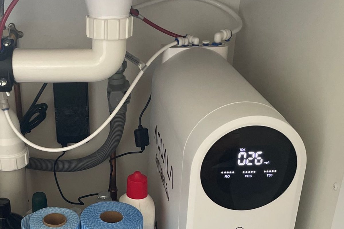 A P500 standing beside a bin and the pipes in an under-sink cupboard.
